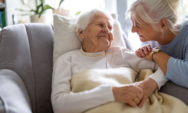 female caregiver smiling at elderly woman
