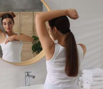 Woman doing a self-check while looking in the mirror