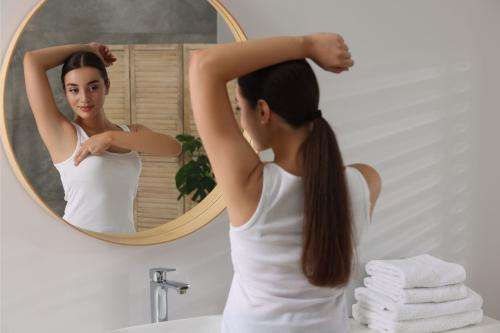 Woman doing a self-check while looking in the mirror